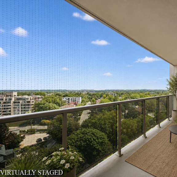 a balcony with a table, chairs, and a potted plant.