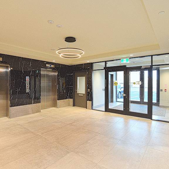 a spacious lobby with marble floors and a ceiling light at roxy apartments, ontario, l8h 0b7