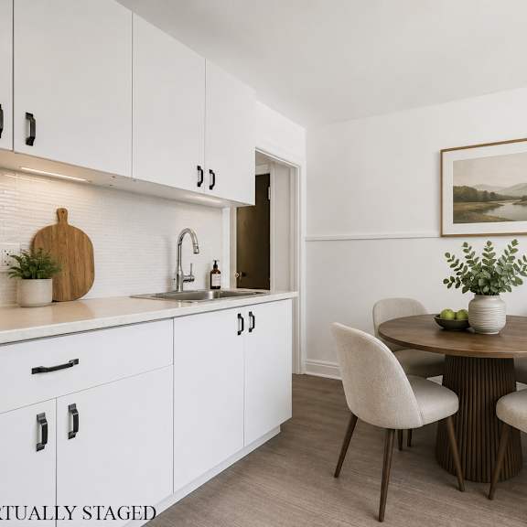 a kitchen with white cabinets and a wooden table with chairs.