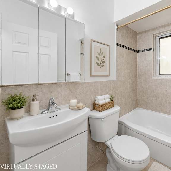 a white bathroom with a toilet, sink, and bathtub.