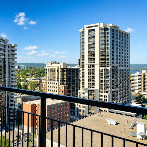 a balcony overlooks a cityscape with buildings and a clear blue sky.