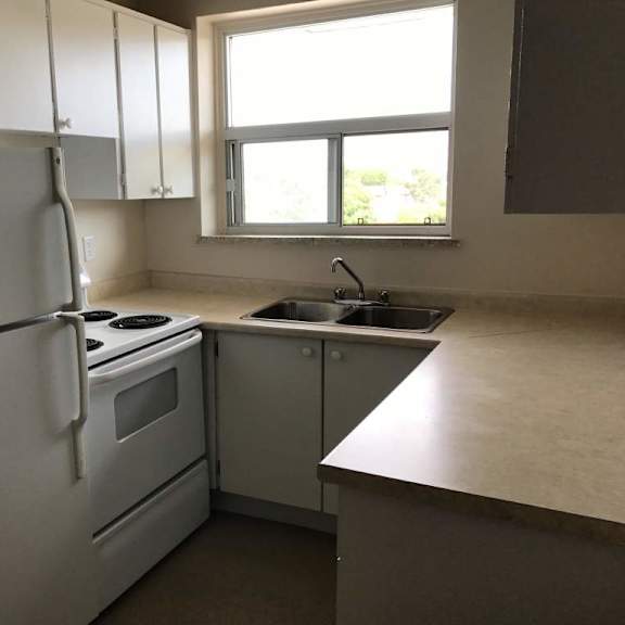 a kitchen with white appliances and a window.