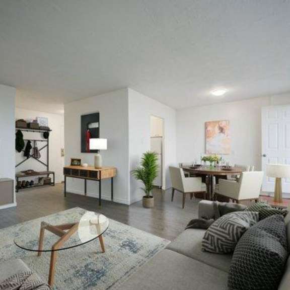 a living room with a grey couch and a glass coffee table.