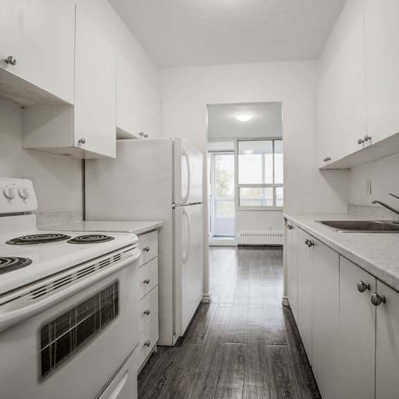 a kitchen with white cabinets and a stove top oven.
