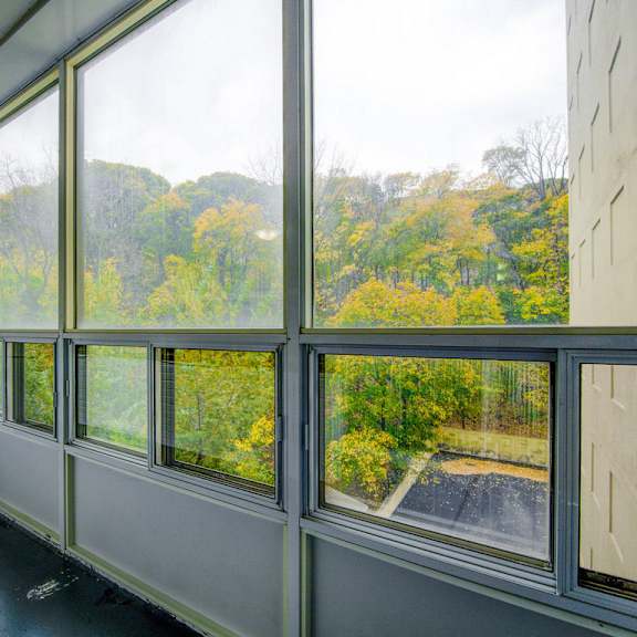 a room with large windows overlooking a tree-filled landscape.