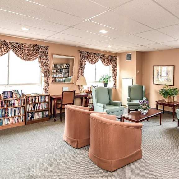 a library with multiple chairs and bookshelves.