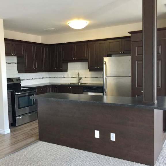 a kitchen with dark brown cabinets and a black oven.