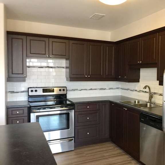 a kitchen with dark brown cabinets and stainless steel appliances.