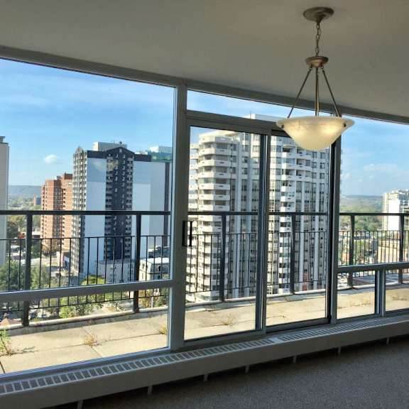 a view of a cityscape from a balcony with a hanging light fixture.