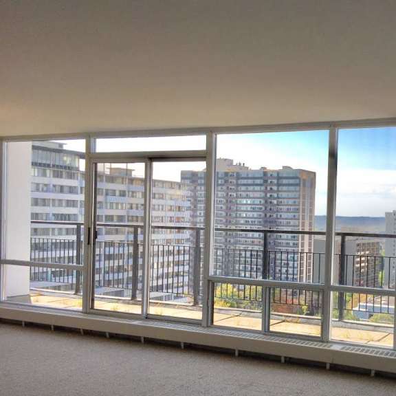 a view of a cityscape from a window in an empty room.