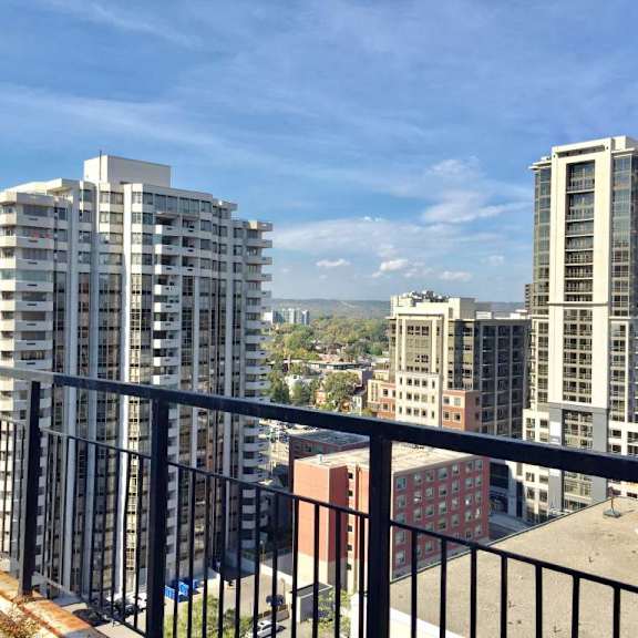 a cityscape with buildings and a balcony in the foreground.