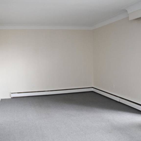 a room with a grey carpet and white walls.