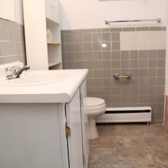 a bathroom with a toilet, sink, and bathtub.