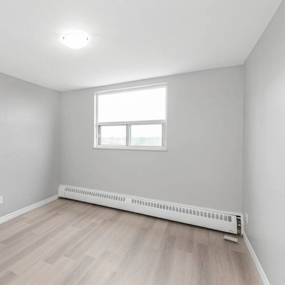 a room with a window and a radiator on the floor.