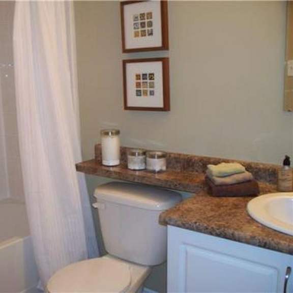 a bathroom with a toilet, sink, and a shower curtain.