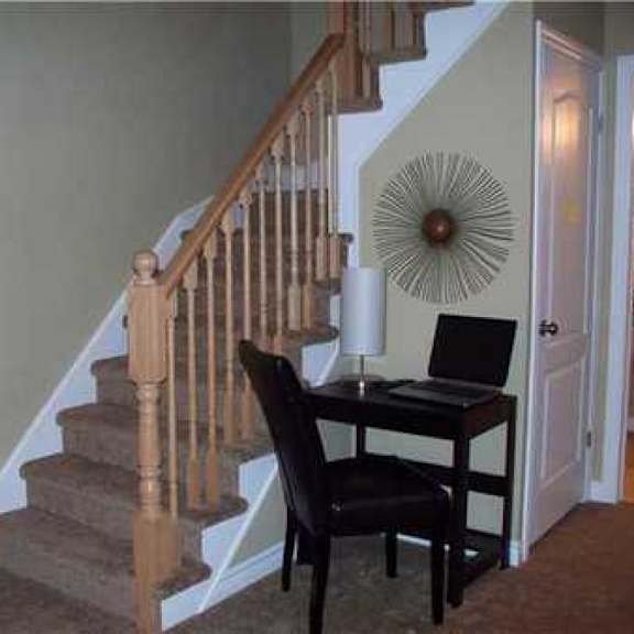 a black chair is in front of a desk with a laptop on it.