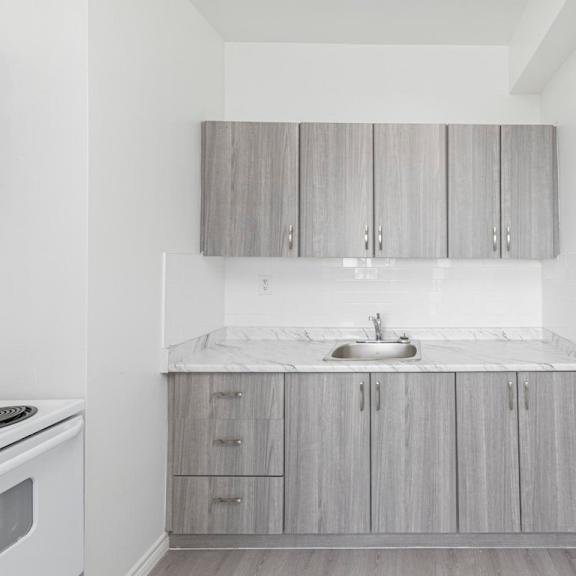 a kitchen with a white counter top and grey cabinets.