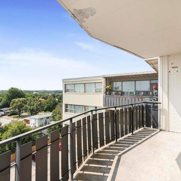 a balcony with a metal railing and steps leading to a building.