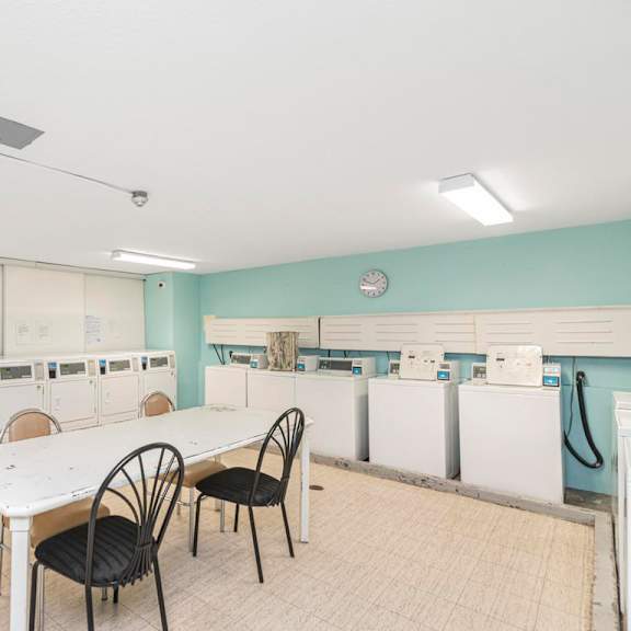 a laundry room with a table and chairs.