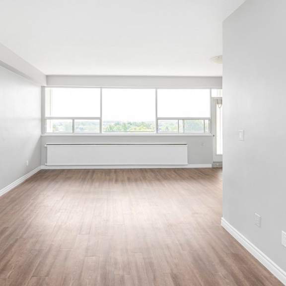 a room with wooden flooring and a large window.