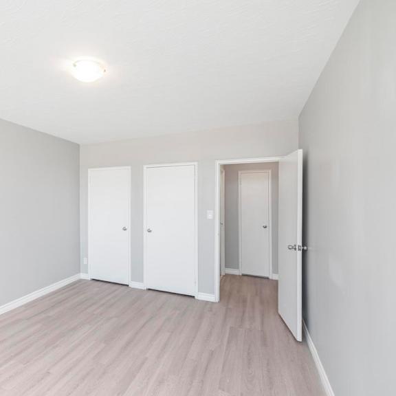 a room with a white door and a light on the ceiling.