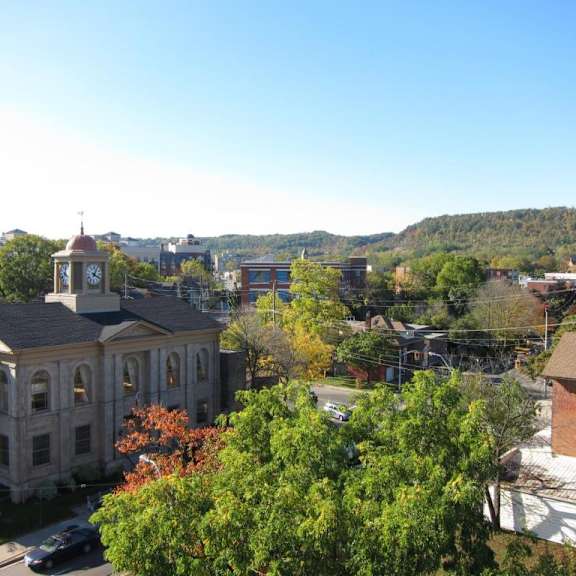 a clock tower stands atop a building in a town.