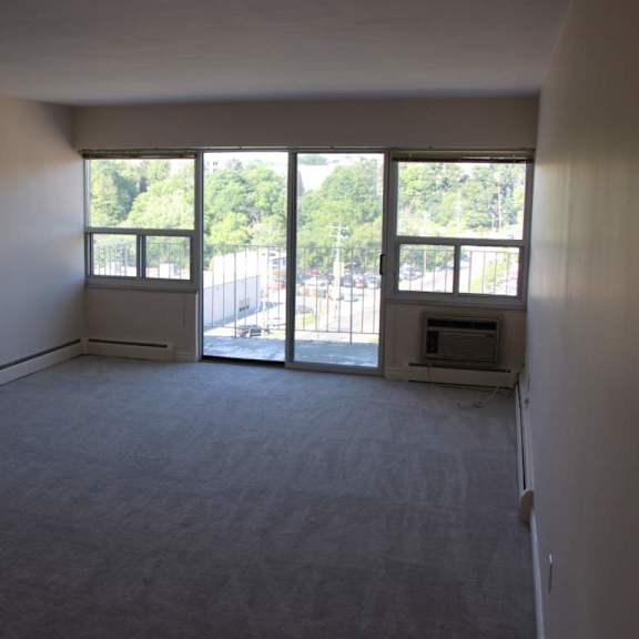 a large empty room with a fireplace and sliding glass doors.