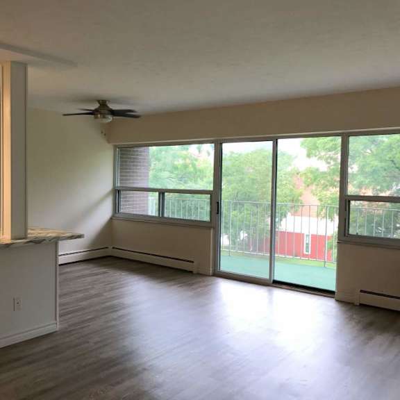 a kitchen with a refrigerator, cabinets, and a countertop.