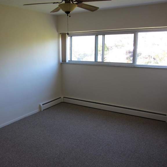a room with a ceiling fan and a window.