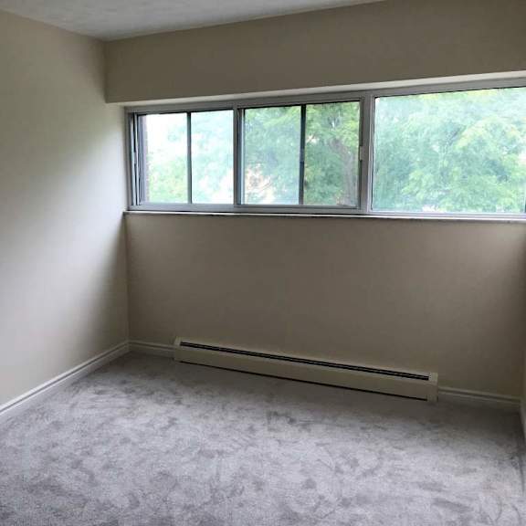 a room with a carpeted floor and a window.