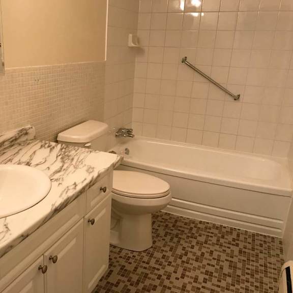 a white toilet sits next to a sink in a bathroom.