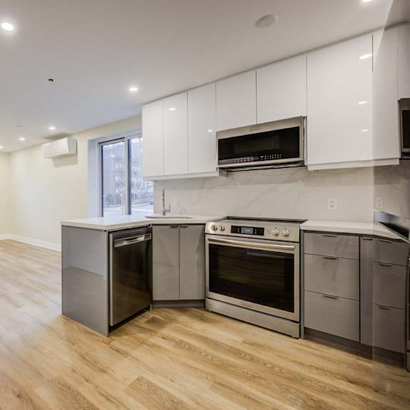 a kitchen with wooden floors and stainless steel appliances.