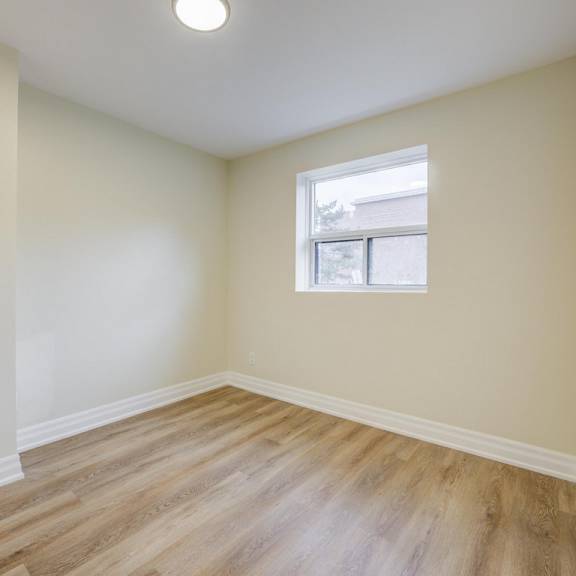 a room with a window and wooden flooring.