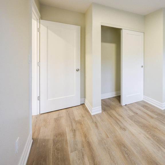 a room with two doors and a wooden floor.