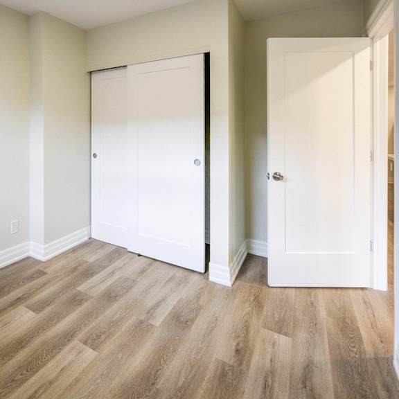 a room with a white door and a wooden floor.
