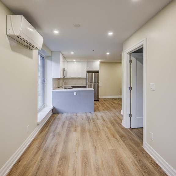 a long hallway with a kitchen at the end.