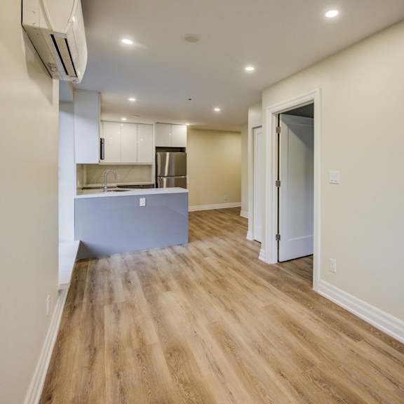 a kitchen with a wooden floor and white walls.