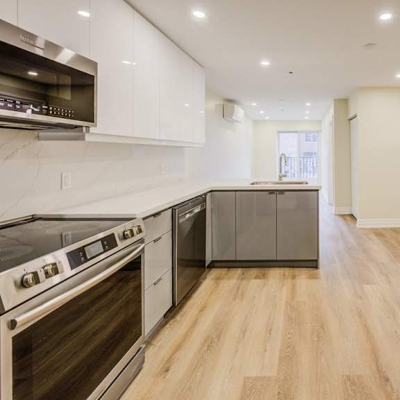 a modern kitchen with white cabinets and stainless steel appliances.