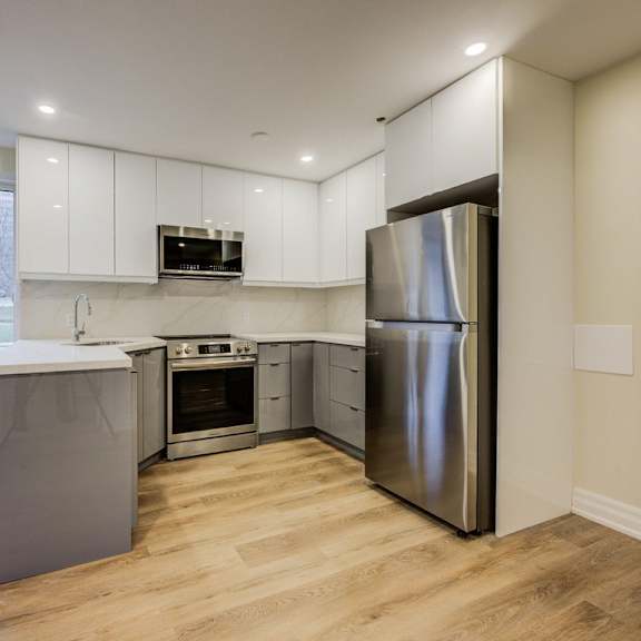 a kitchen with a refrigerator, oven, and microwave.