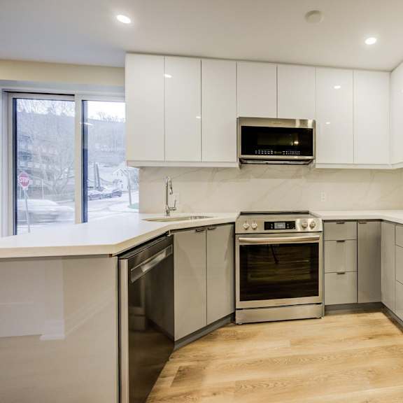 a modern kitchen with stainless steel appliances and white cabinets.