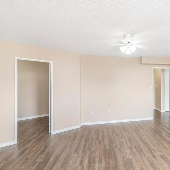 a room with a ceiling fan and light, and a door on the right.
