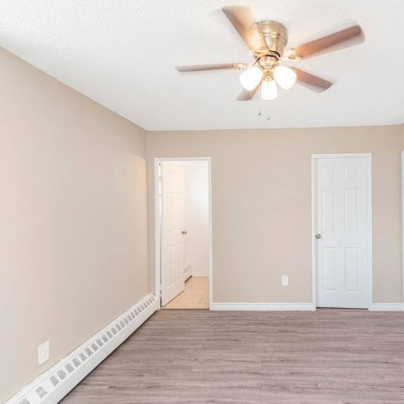 a room with a ceiling fan and two doors.