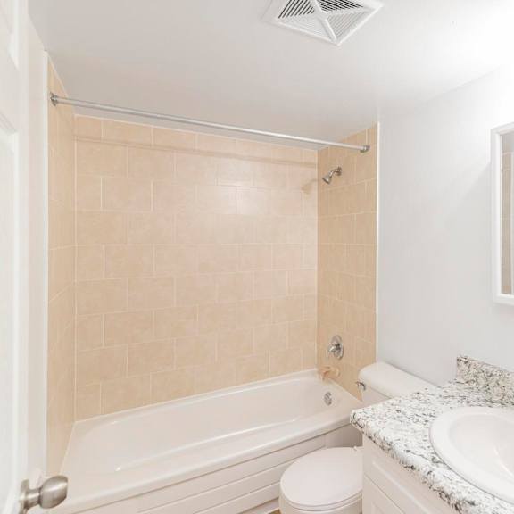 a white bathroom with a toilet, sink, and bathtub.