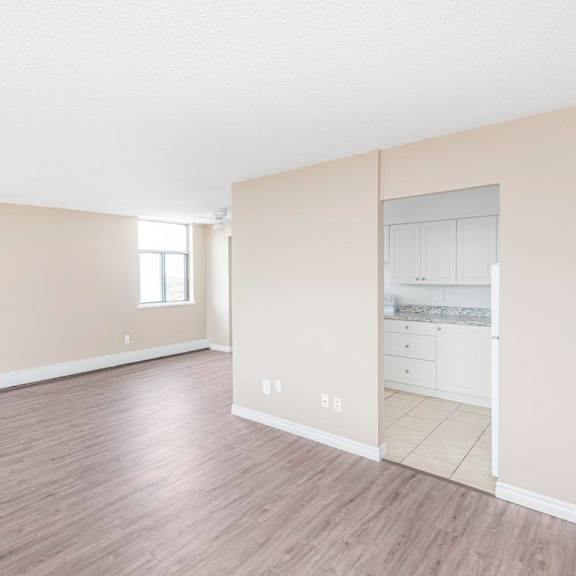 a room with a wooden floor and a wall with a window.