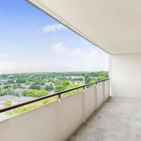 a balcony with a view of a green landscape.