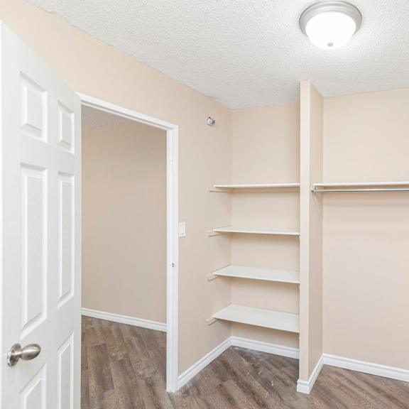 a room with a white door and shelves on the wall.
