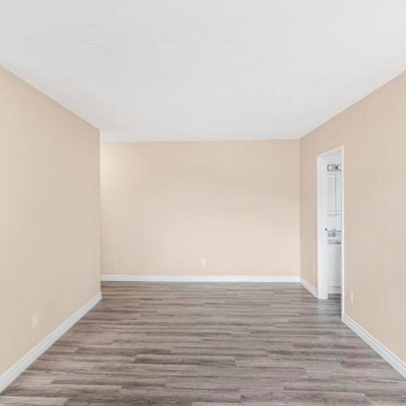 a room with wooden flooring and a white door.