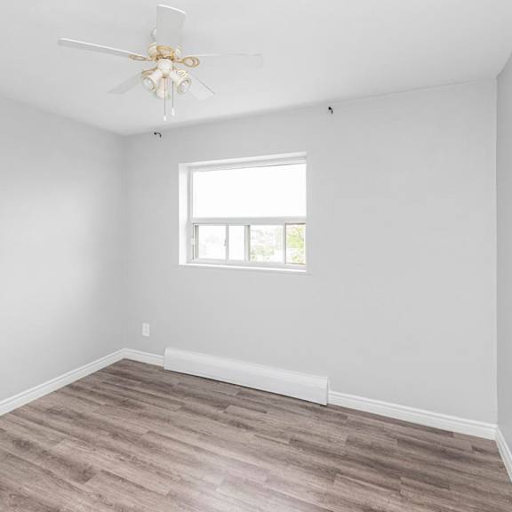 a room with a ceiling fan and a window.