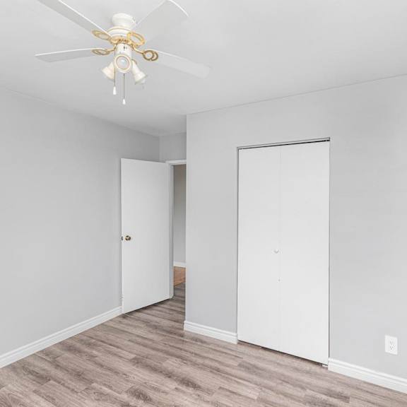 a room with a ceiling fan and two doors.