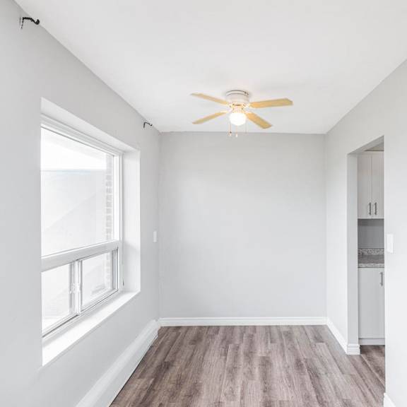 a room with a ceiling fan and a window.